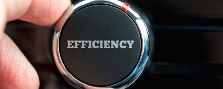 Close up of the fingers of a man turning a power button reading - Efficiency - on an item of electronic equipment.