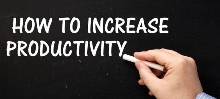 Male hand wearing a business shirt writing the phrase How to Increase Productivity on a blackboard