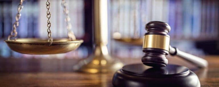 Judge gavel, scales of justice and law books in court