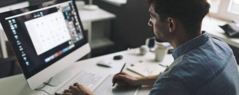 Modern designer sitting in front of computer and working in office