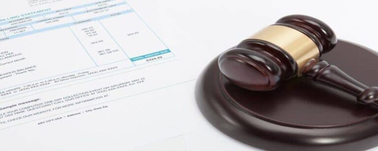 Unpaid bill with wooden gavel over it