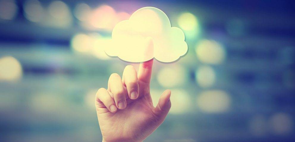 Hand pressing a cloud computing icon on blurred cityscape background